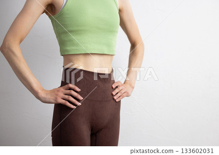 特寫鏡頭：一位身穿運動服的女性線條優美的腹部 133602031