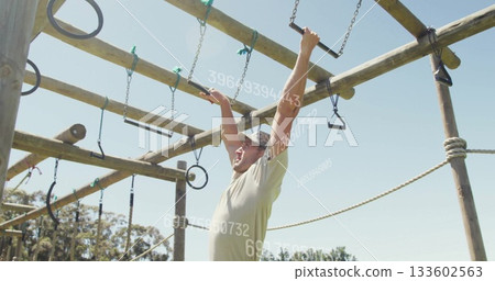 Climbing wooden beams on obstacle frame at grassy field wearing t-shirt and cap with data overlay Climbing wooden beams on obstacle frame at grassy field wearing t-shirt and cap with data overlay 133602563