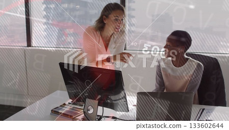 Leaning woman wearing blouse pointing at monitor in office, with color swatch book, copy space 133602644