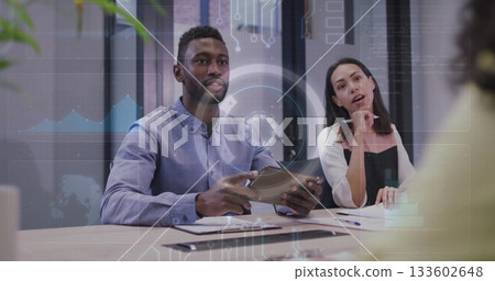 Analyzing data with tablet, documents, pens by colleagues at glass partitioned conference table Analyzing data with tablet, documents, pens by colleagues at glass partitioned conference table 133602648