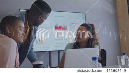 Three colleagues wearing business attire discussing data in meeting room, with laptop, screen 133602649