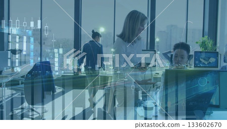 Consulting midlevel woman leaning over seated peer at open-plan office showing tablet and monitors 133602670