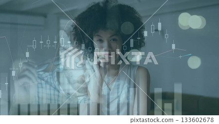 Reviewing financial charts, two colleagues adjusting glasses and resting chin in office, with sofa Reviewing financial charts, two colleagues adjusting glasses and resting chin in office, with sofa 133602678
