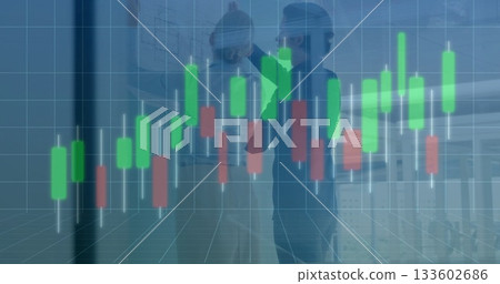 Two professionals in business attire reviewing charts on glass wall at office with chart overlay Two professionals in business attire reviewing charts on glass wall at office with chart overlay 133602686