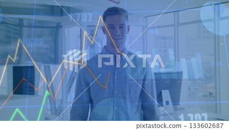 Standing button-up-shirted worker in open-plan office, with computers, line and bar chart overlay 133602687