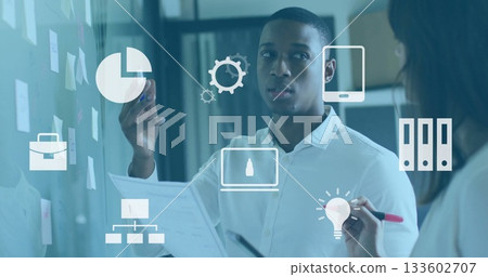 Man and woman brainstorming in office, with glass board markers, document, notes and floating icons Man and woman brainstorming in office, with glass board markers, document, notes and floating icons 133602707