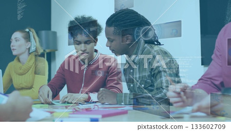 Collaborating colleagues studying sticky notes and writing on notepad in meeting room, headset Collaborating colleagues studying sticky notes and writing on notepad in meeting room, headset 133602709