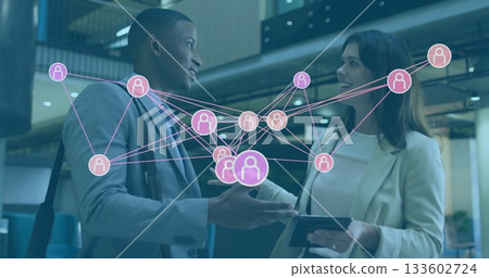Talking business man and woman showing digital network overlay in office lobby, with tablet device 133602724