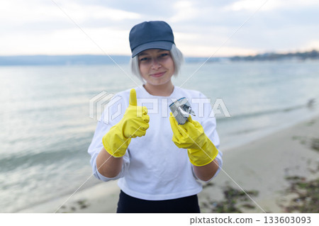 volunteer showing a collected metal can during beach cleanup, highlighting pollution, ecology, environment protection, sustainability and coastal awareness. volunteer showing a collected metal can during beach cleanup, highlighting pollution, ecology, environment protection, sustainability and coastal awareness. 133603093