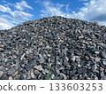 a pile of coarse granite against a blue sky. Crushed stone building materials 133603253