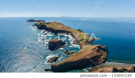 Wide drone panorama of Ponta de Sao Lourenco peninsula Madeira, bright postcard colors reveal green grass lava cliffs and azure Atlantic water in cinematic seascape Wide drone panorama of Ponta de Sao Lourenco peninsula Madeira, bright postcard colors reveal green grass lava cliffs and azure Atlantic water in cinematic seascape 133603288