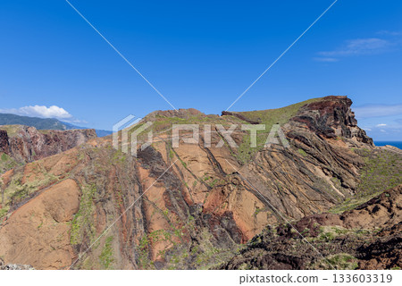 Sweeping view of Sao Lourenco cliffs with rugged volcanic layers and patches of greenery Sweeping view of Sao Lourenco cliffs with rugged volcanic layers and patches of greenery 133603319