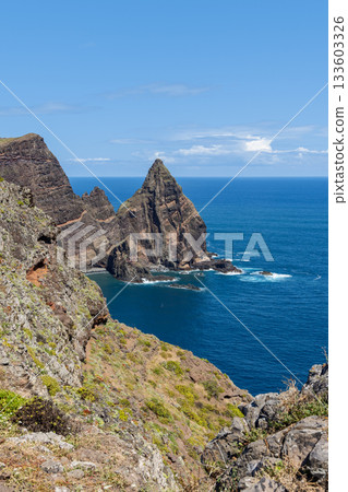 Sheer sea stacks at Sao Lourenco Madeira rise above turquoise surf in bright sunlight 133603326