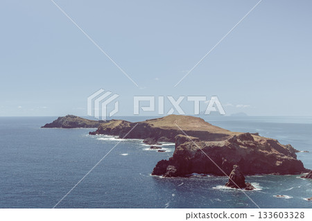 Muted earthy cliffs and headland at Ponta de Sao Lourenco Madeira with calm ocean view 133603328