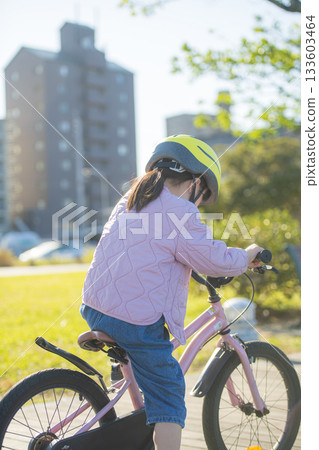 Kindergartener practicing on a pink bicycle Kindergartener practicing on a pink bicycle 133603464