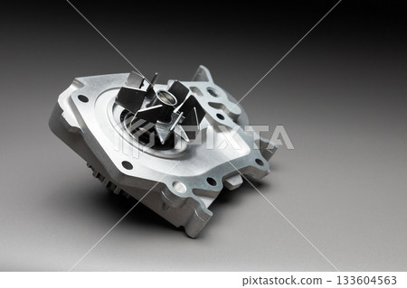 High-quality spare parts for your car. Car maintenance. New water pump for the engine cooling system on a gray gradient background. High-quality spare parts for your car. Car maintenance. New water pump for the engine cooling system on a gray gradient background. 133604563