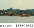 Wooden tourist boats navigate west lake in Hangzhou, China near pagoda temple on hill at dusk 133604643