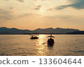Evening scenic view of West Lake with tourists in boats during sunset 133604644