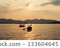 Evening scenic view of West Lake with tourists in boats during sunset 133604645