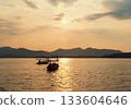 Evening scenic view of West Lake with tourists in boats during sunset 133604646