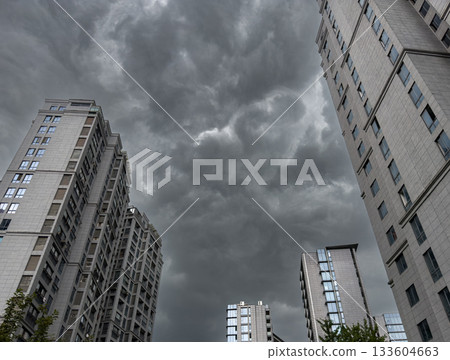 Tall residential buildings under a dramatic cloudy sky during daytime in China Tall residential buildings under a dramatic cloudy sky during daytime in China 133604663