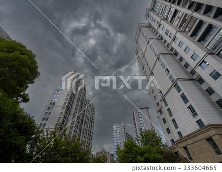 Tall residential buildings under a dramatic cloudy sky during daytime in China 133604665