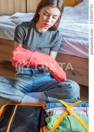 Woman packing clothes preparing for travel trip Woman packing clothes preparing for travel trip 133604755