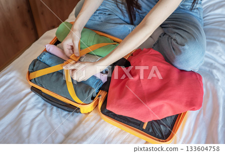Woman packing clothes into suitcase for vacation trip 133604758
