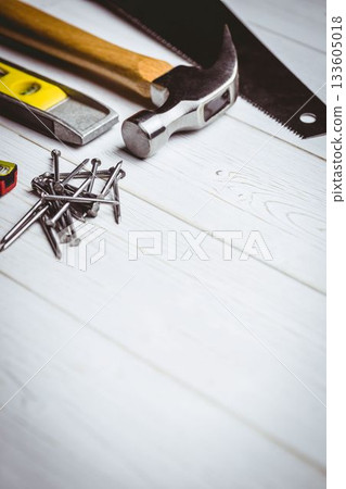 Claw hammer is resting in flat design workshop with nails, level, saw, tape measure, copy space 133605018