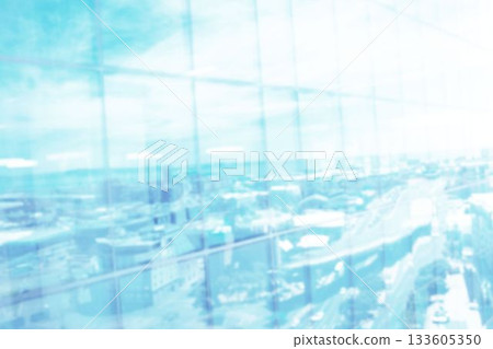 Defocussed image of modern cityscape and blue sky reflected in glass building front, with copy space 133605350