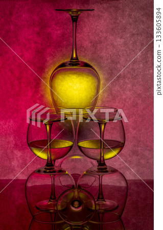 Still life with glassware with liquid on colored background 133605894