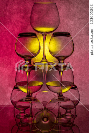 Still life with glassware with liquid on colored background Still life with glassware with liquid on colored background 133605898