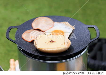 Close-up of a black multi-griddle and ingredients, with grass green in the background Close-up of a black multi-griddle and ingredients, with grass green in the background 133606034