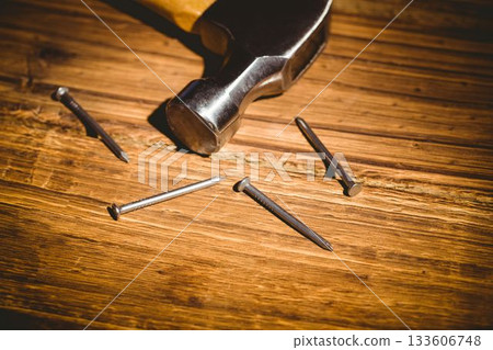 Hammer head with handle is being shown in flat design workshop scene, highlighting steel nails 133606748