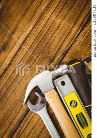 showing flat design hammer, wrench, spirit level, screwdriver, tape measure resting on wooden plank showing flat design hammer, wrench, spirit level, screwdriver, tape measure resting on wooden plank 133607139