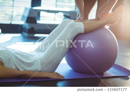 Woman exercising with ball at gym 133607177