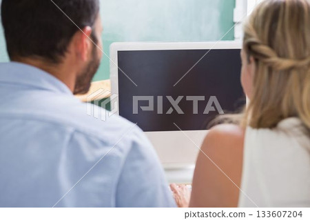 Colleagues looking at computer Colleagues looking at computer 133607204