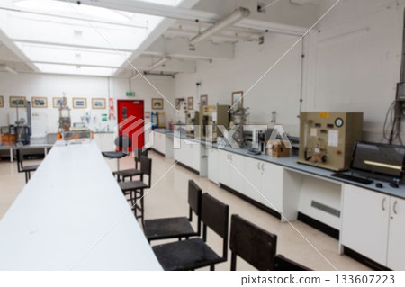 Long white laboratory bench with black stools is spanning flat design lab, showing instruments 133607223