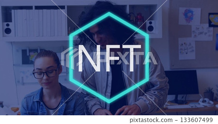 Collaborating colleagues examining screen at modern office desk, with turquoise NFT hexagon overlay 133607499