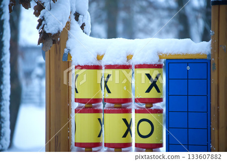 Tic-tac-toe game on a playground covered in fresh snow during winter Tic-tac-toe game on a playground covered in fresh snow during winter 133607882