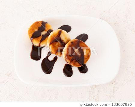 Curd fritters with chocolate on the porcelain plate. 133607980