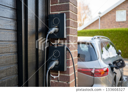 home electric car charging station on brick wall 133608327