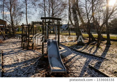 metal slide on wooden playground in early winter sunshine 133608338