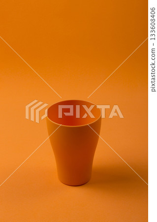 Orange cup on an orange background Orange cup on an orange background 133608406