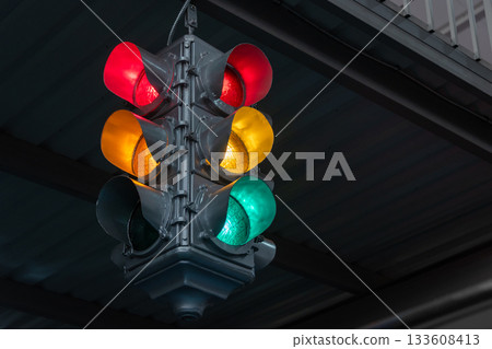 Traffic light under the bridge with red, yellow and green colors. Safety regulations. Traffic light in the city closeup 133608413