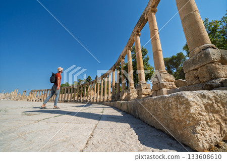 Tourist admiring ancient Oval Plaza colonnade in Jerash ruins, Jordan Tourist admiring ancient Oval Plaza colonnade in Jerash ruins, Jordan 133608610