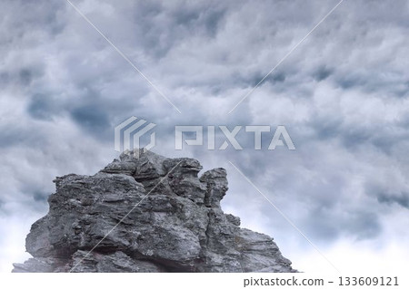 flat design illustration is showing layered jagged grey rock formation below dense cloud cover 133609121