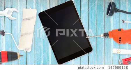 Tools and tablet on wooden background Tools and tablet on wooden background 133609138
