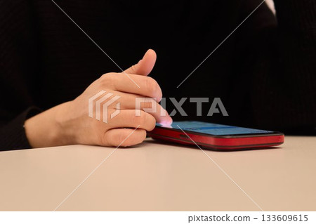 Nightly hand gestures on smartphone, Fingers tapping and engaging with phone during night hours, Closeup shot capturing hand movements interacting with mobile device at night Nightly hand gestures on smartphone, Fingers tapping and engaging with phone during night hours, Closeup shot capturing hand movements interacting with mobile device at night 133609615