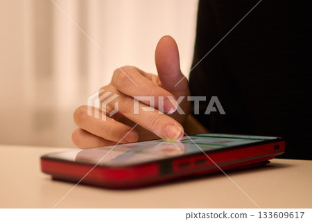 Nightly hand gestures on smartphone, Fingers tapping and engaging with phone during night hours, Closeup shot capturing hand movements interacting with mobile device at night Nightly hand gestures on smartphone, Fingers tapping and engaging with phone during night hours, Closeup shot capturing hand movements interacting with mobile device at night 133609617